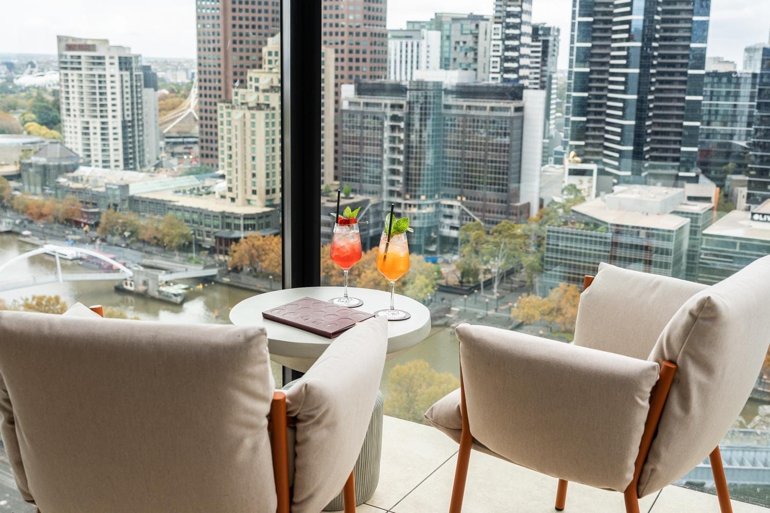 Guests enjoying drinks with panoramic city views at Fleet Rooftop Bar